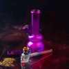 a purple glass bong with a skull and a glass pipe